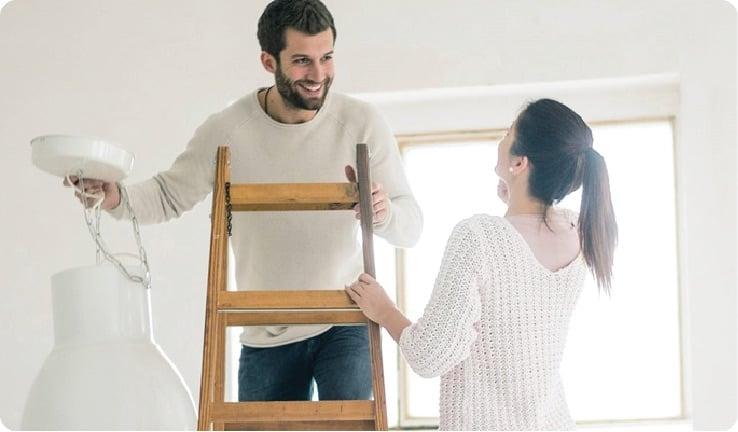 a man and woman holding a wooden chair