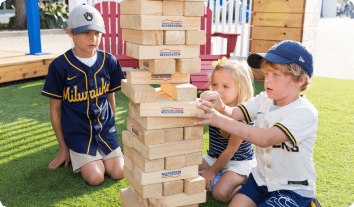 a group of kids playing with a stack of wood blocks