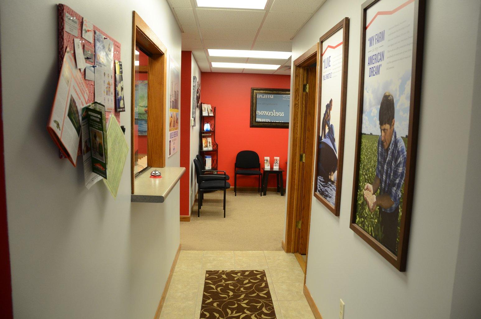 a hallway with a desk and chairs