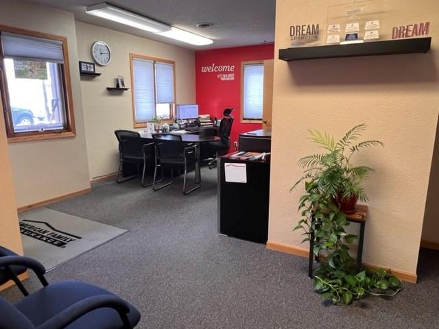 a room with a desk and chairs