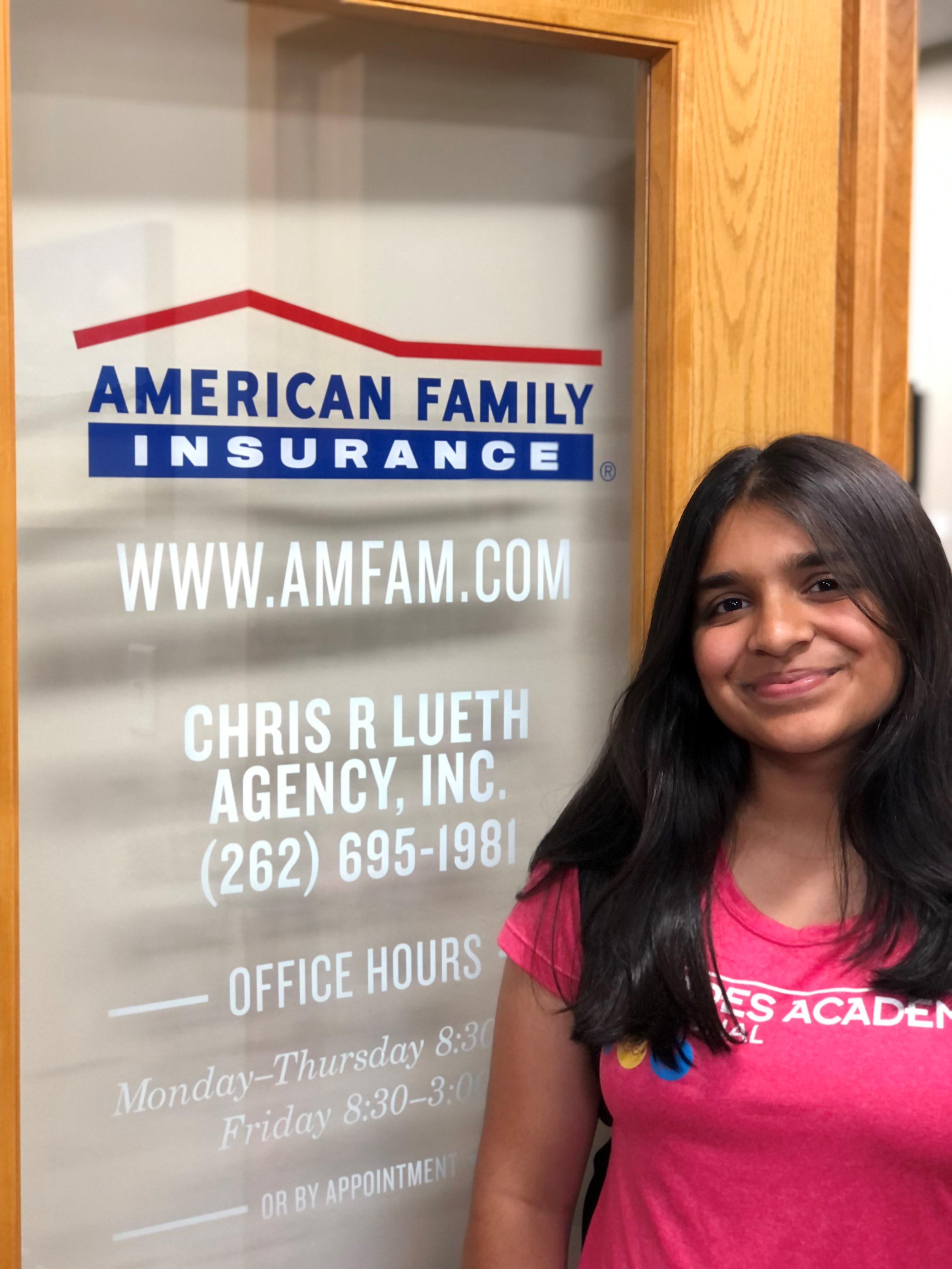 a woman smiling in front of a sign