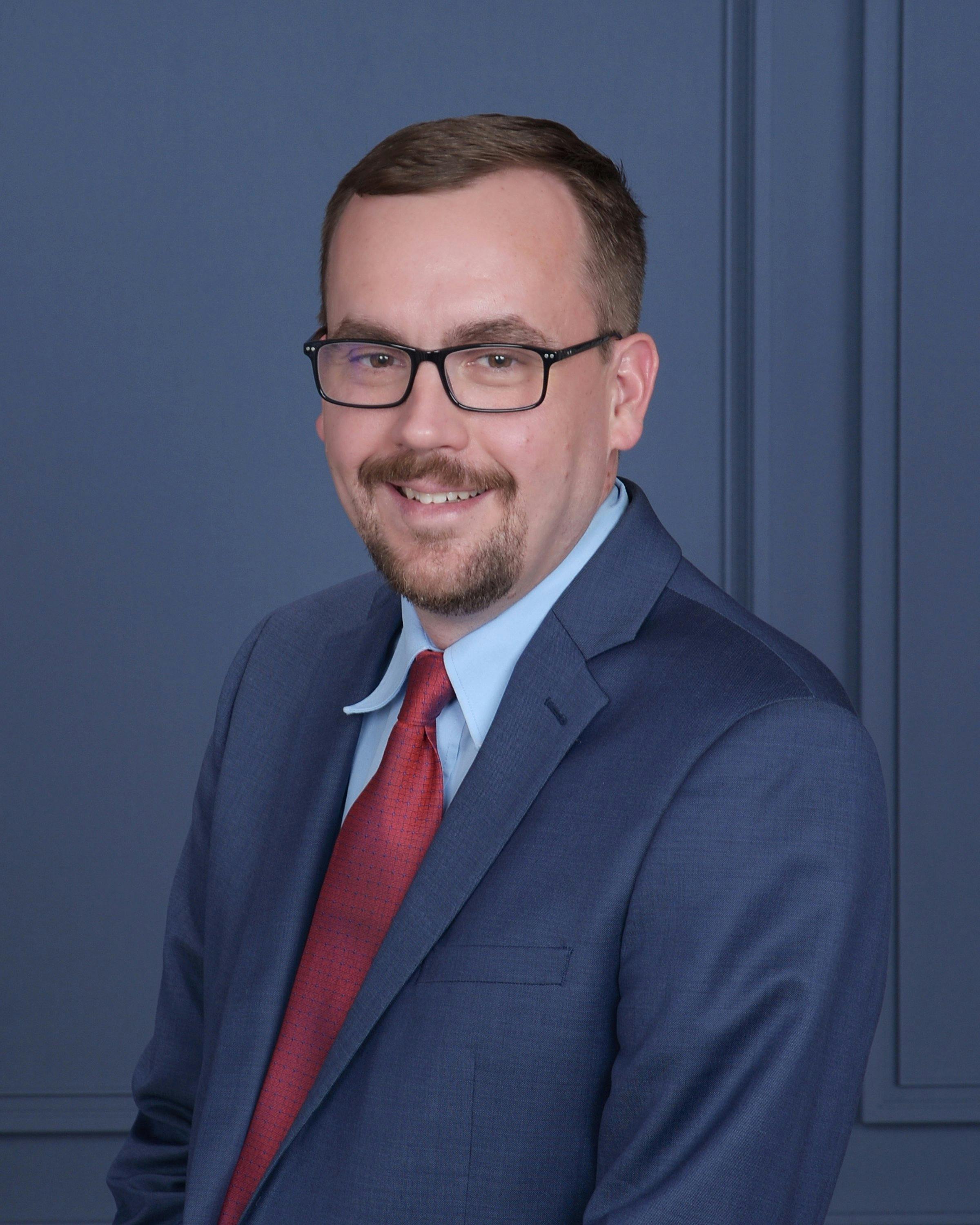 a man wearing glasses and a suit