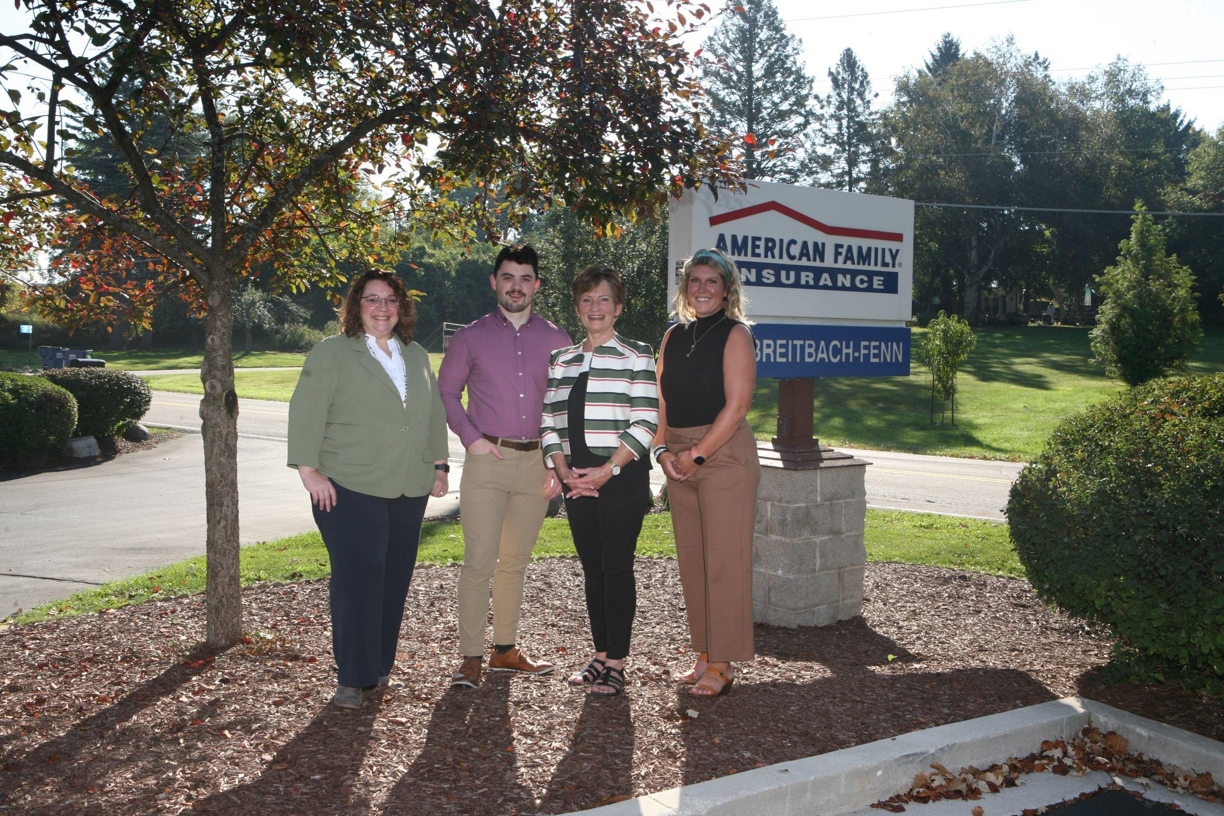 a group of people posing for a photo in front of a sign