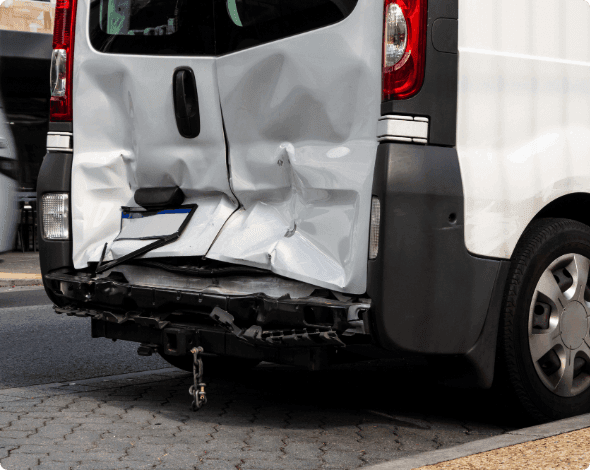 A van with a large dent in its back doors.