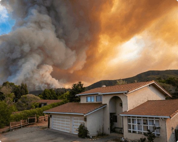 House with a looming wildfire in the background. 