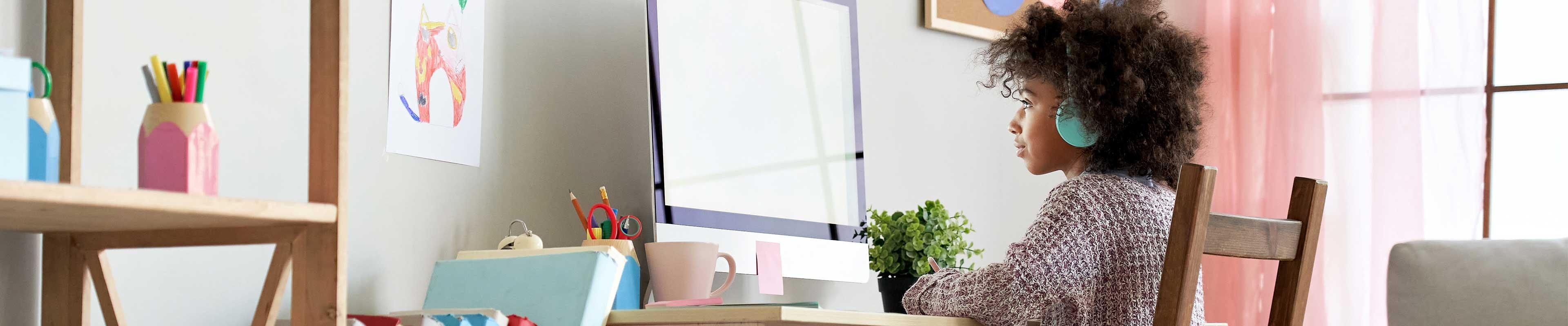 Young girl sitting in front of her computer