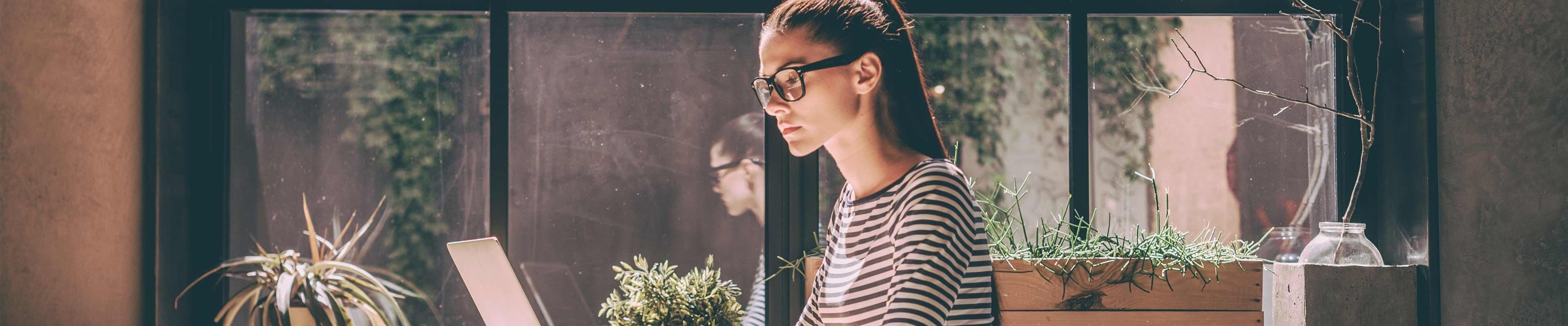 Young woman sitting at a computer working on something