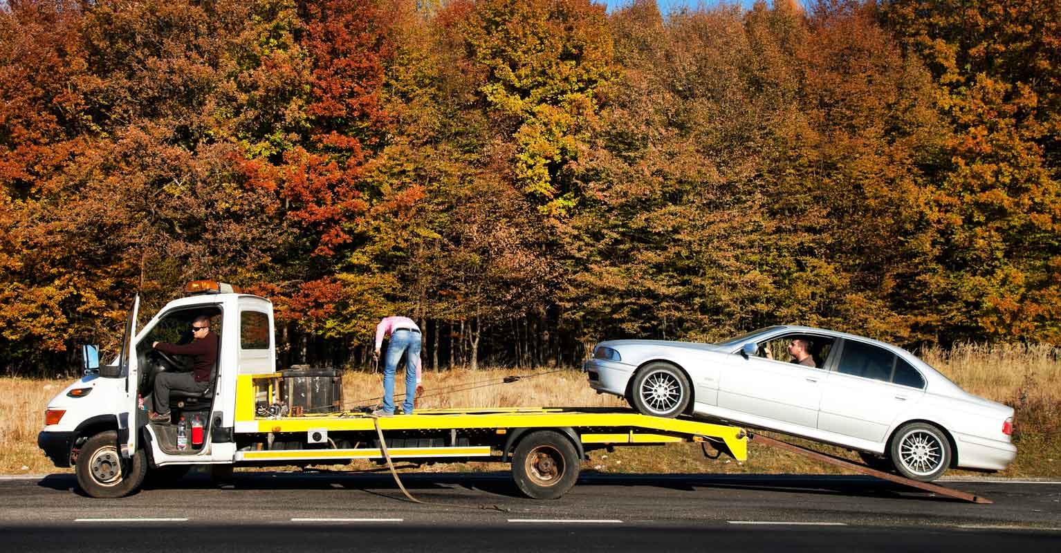 Car being loaded onto a flatbed tow truck
