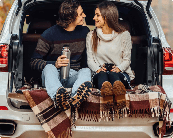 Image of a couple smiling at one another in a car.