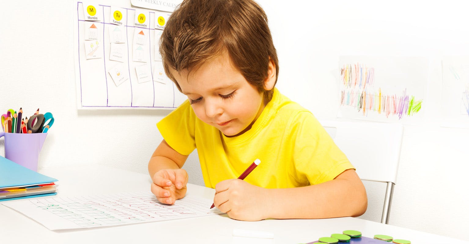 Child writing at desk to get ready for back to school