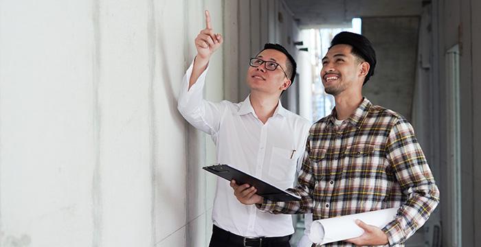 a couple of men smiling and holding a tablet